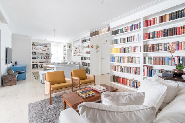 Uma sala de estar com uma prateleira gigante de livros 