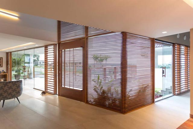 Foto de um ambiente integrado com persianas em madeira 