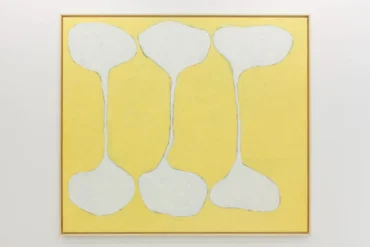 Pintura abstrata emoldurada com fundo amarelo e três formas brancas em ampulheta, lembrando ossos, dispostas verticalmente na tela.