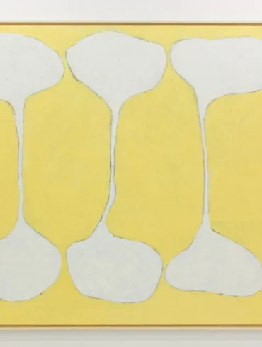 Pintura abstrata emoldurada com fundo amarelo e três formas brancas em ampulheta, lembrando ossos, dispostas verticalmente na tela.